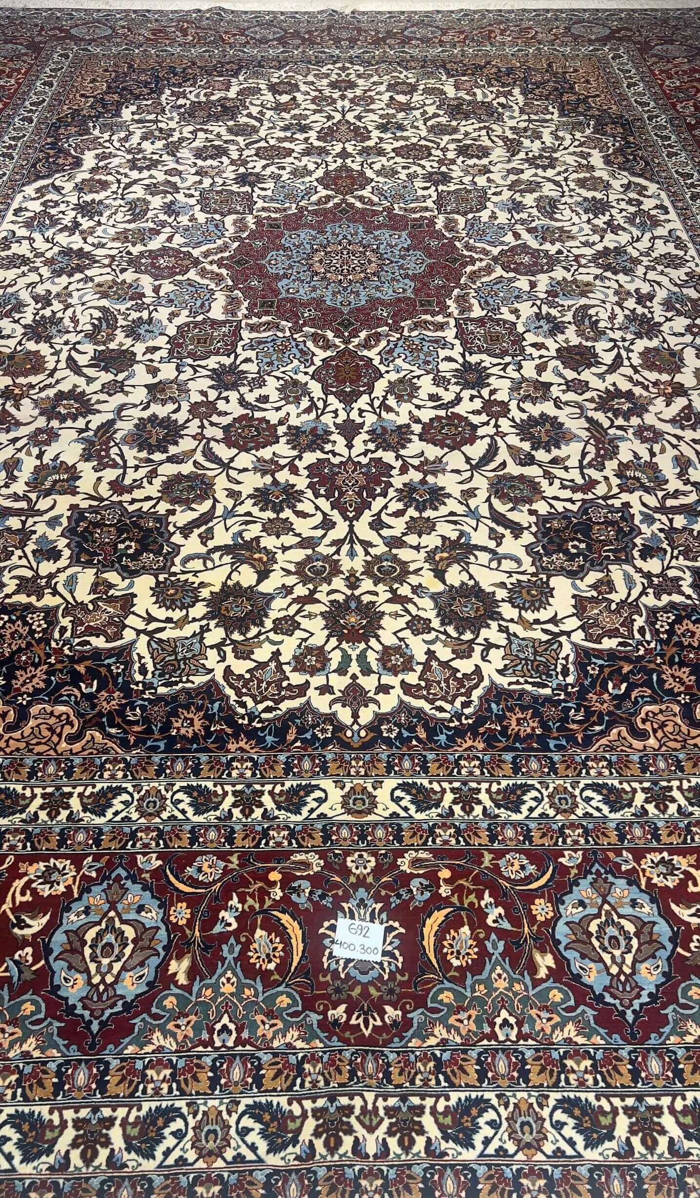 "Handwoven Isfahan rug by Master Hamid Seirafian, featuring intricate floral patterns on an ivory background."